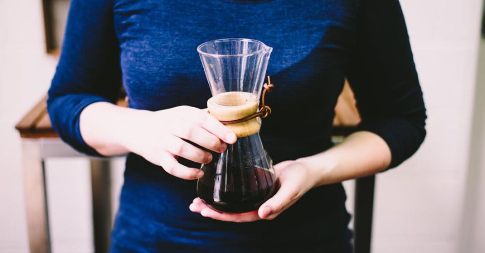 Cafes - Person Holding Clear Glass Vase