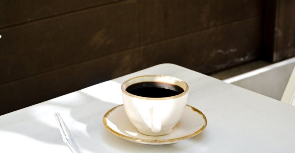 Cafes - A white table with a cup of coffee on it