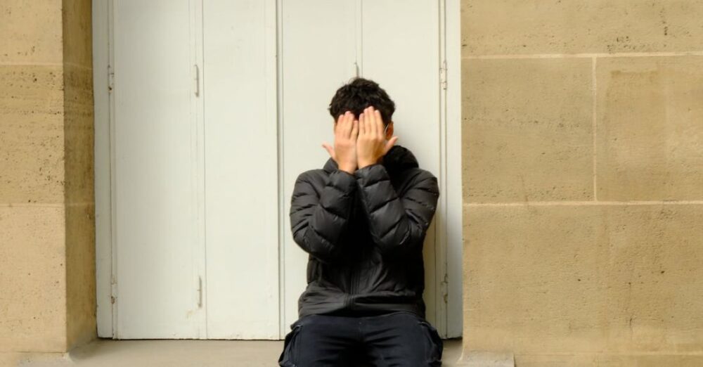 Hideaways - A boy hiding face in Paris street