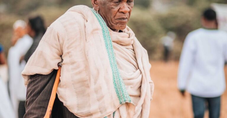 Villages - An old man with a cane walking through a field