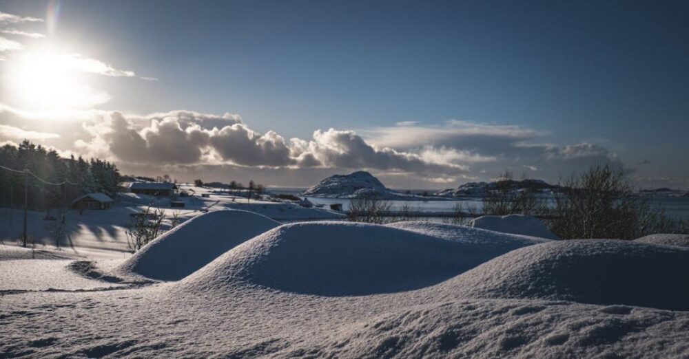 Villages - A snow covered hill with a sun shining in the sky