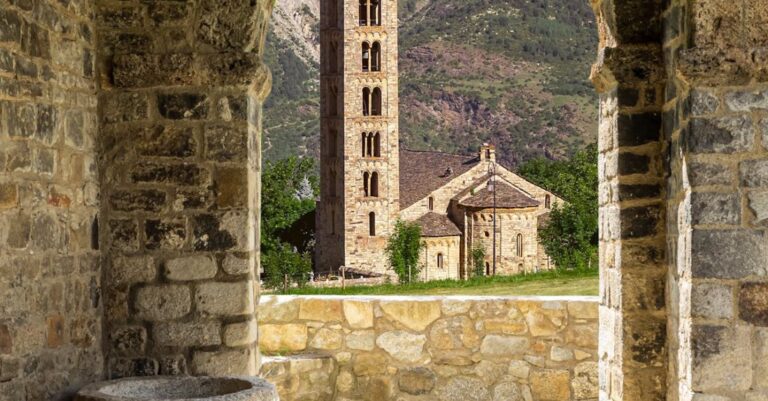 Villages - A stone archway with a window and a church